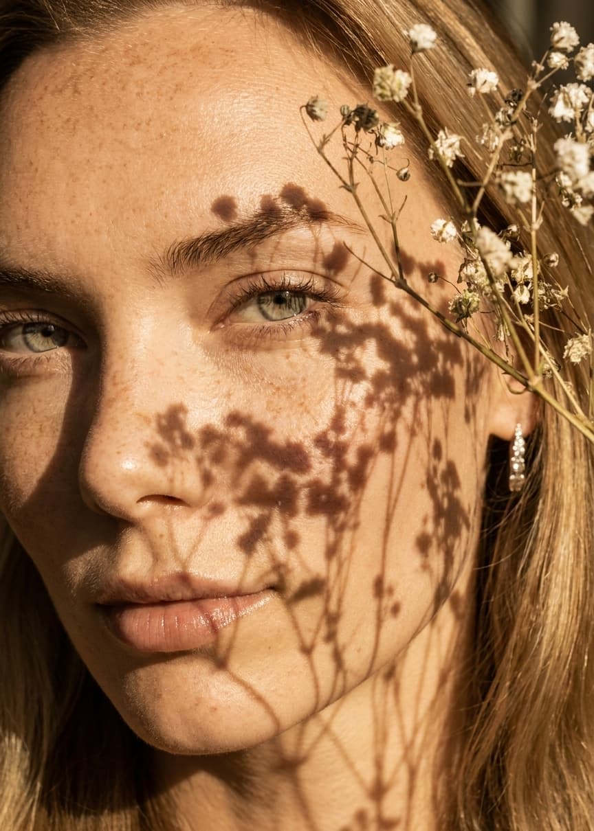 Felicia van Eijk in golden light with the shadow of dried flowers across her face